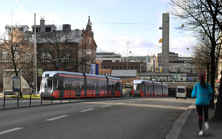 Kuvassa näkyy Tampereen punainen raitiovaunu liikenteessä kaupungin keskustassa.