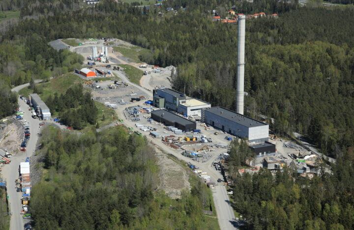 Kuvassa on jätevedenpuhdistamo ilmasta kuvattuna metsämaiseman keskellä.